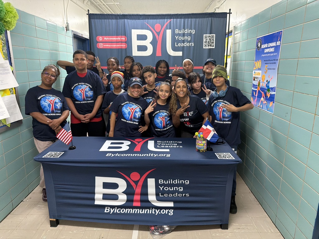 Building Young Leaders students and mentors gathered together at a community engagement event with the BYL banner